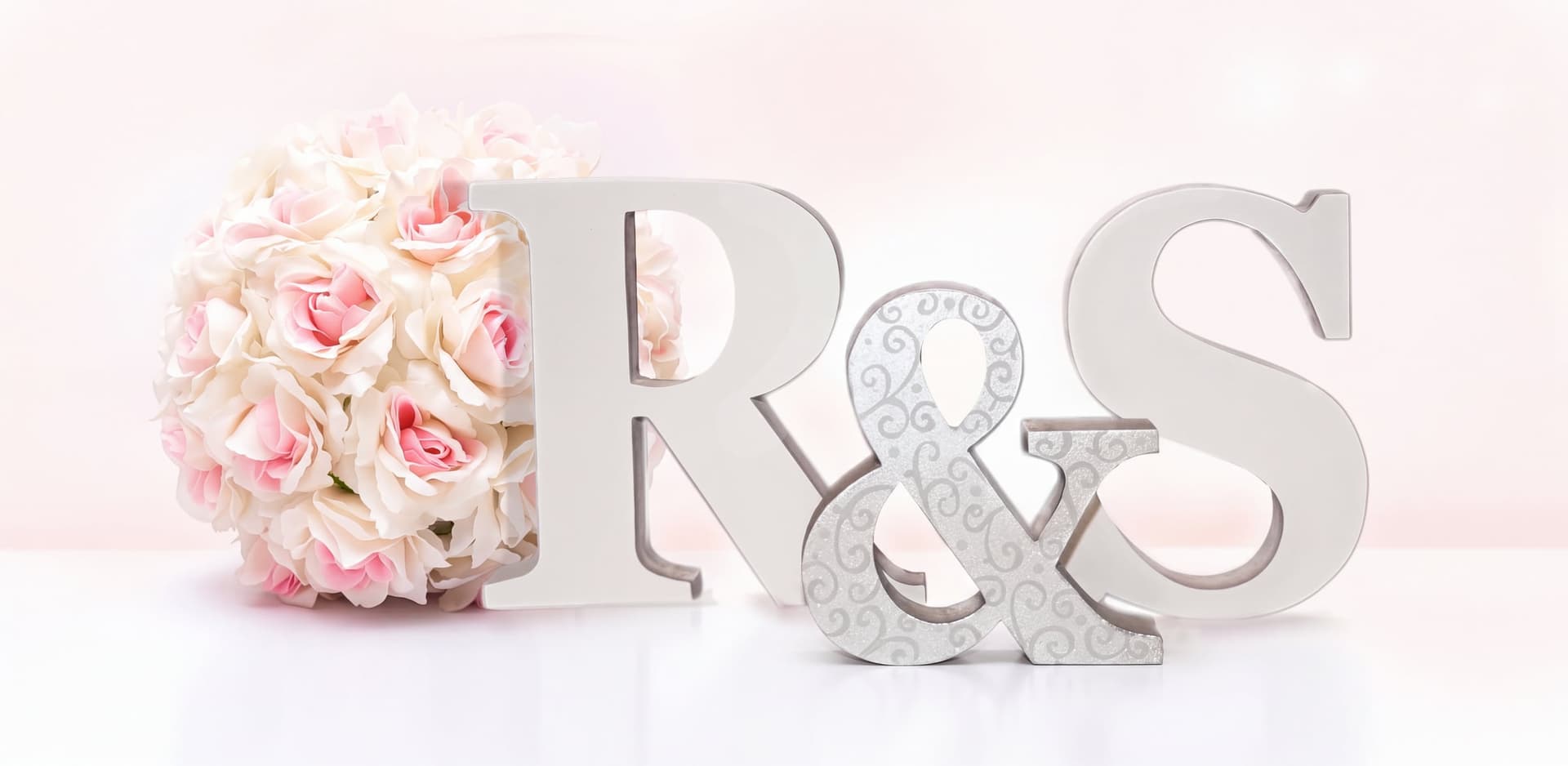 Letras de madera R & S junto a un ramo de rosas para la mesa nupcial